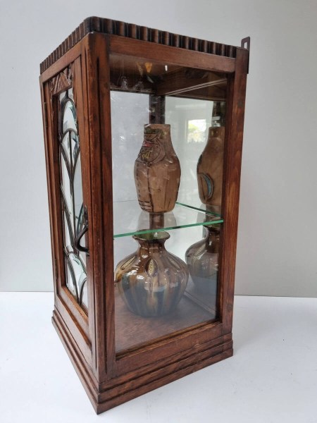 Vintage oak hanging showcase styled with pottery vases on a glass shelf